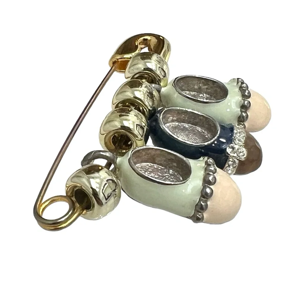 VINTAGE GOLD TONE & ENAMEL SAFETY PIN BROOCH WITH 3 BABY SHOE CHARMS